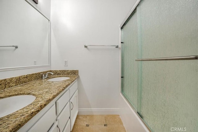 bathroom featuring vanity, tile patterned floors, and bath / shower combo with glass door