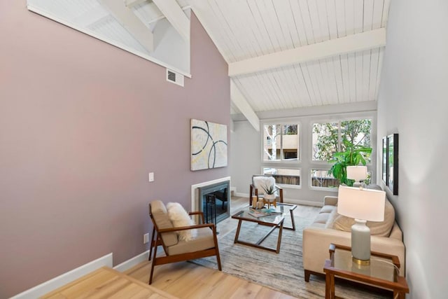 living room featuring hardwood / wood-style flooring, beam ceiling, and high vaulted ceiling