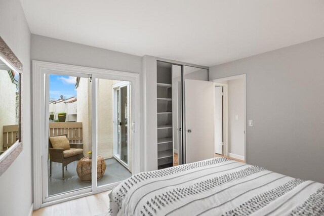 bedroom featuring access to outside, a closet, and wood-type flooring