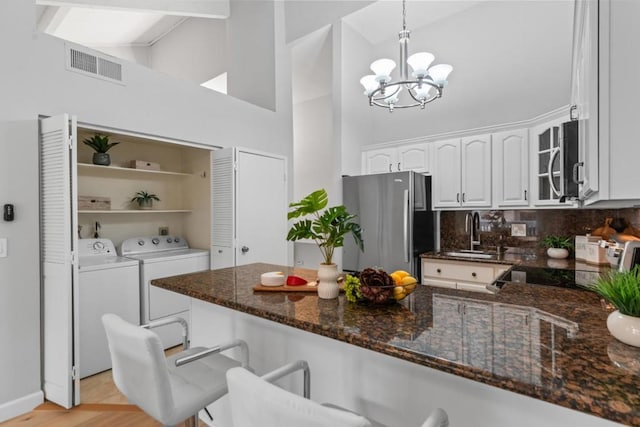 kitchen with stainless steel appliances, white cabinetry, hanging light fixtures, and kitchen peninsula