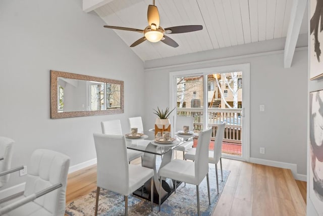 dining room featuring ceiling fan, light hardwood / wood-style floors, and vaulted ceiling with beams