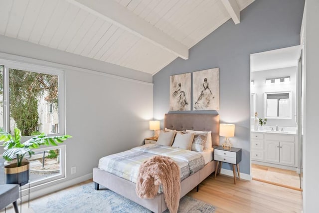 bedroom featuring connected bathroom, vaulted ceiling with beams, sink, and light hardwood / wood-style flooring