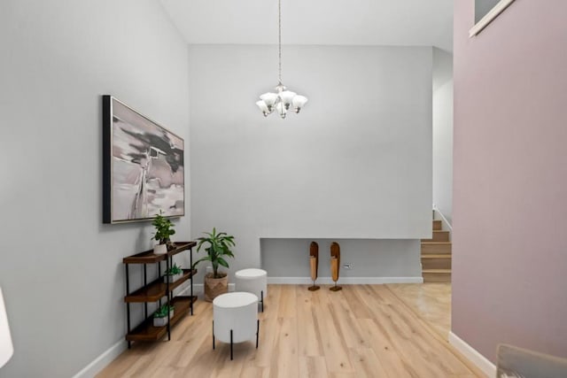 living area with an inviting chandelier and hardwood / wood-style flooring