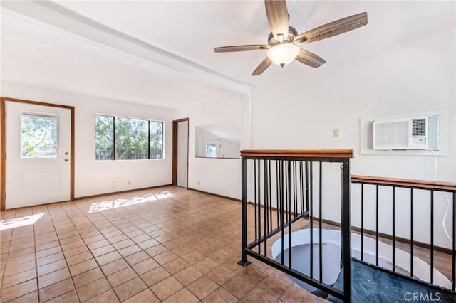 tiled spare room with ceiling fan and a wall unit AC