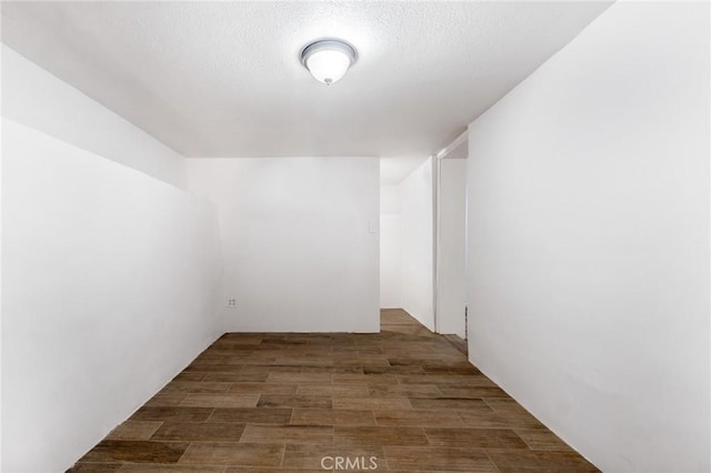 spare room with dark hardwood / wood-style floors and a textured ceiling