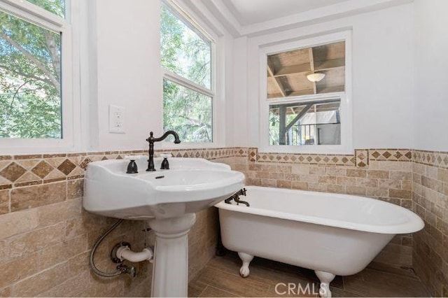 bathroom featuring tile walls and a tub