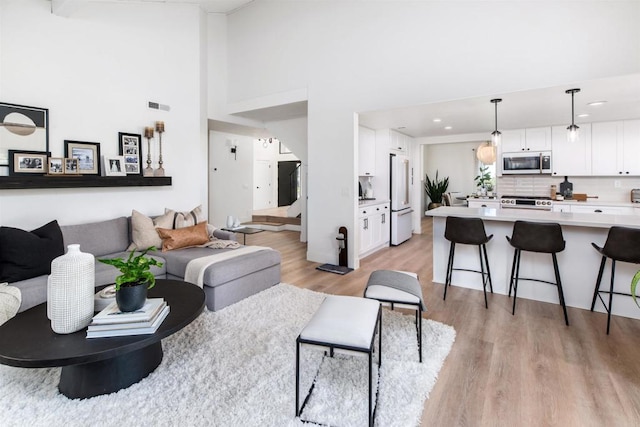 living room featuring light hardwood / wood-style flooring and a high ceiling