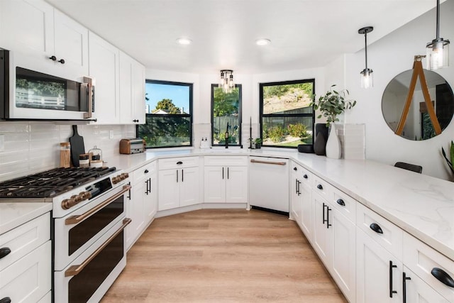 kitchen with tasteful backsplash, pendant lighting, white cabinets, and white appliances