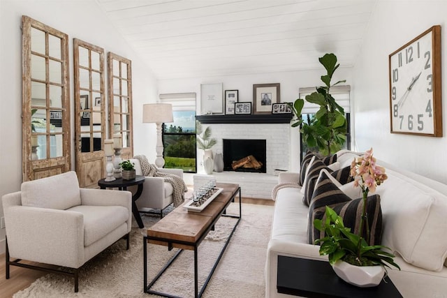 living room with lofted ceiling, wood ceiling, a fireplace, and light hardwood / wood-style floors