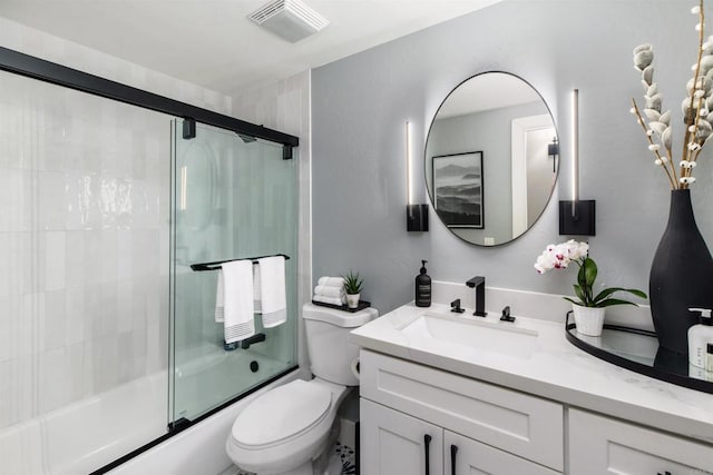 full bathroom featuring bath / shower combo with glass door, vanity, and toilet