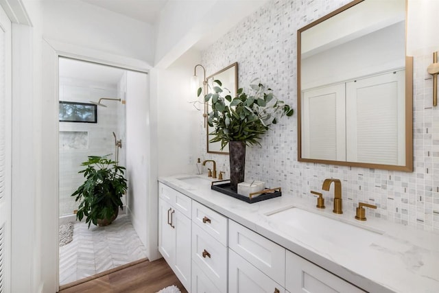 bathroom with tasteful backsplash, vanity, parquet floors, and a tile shower