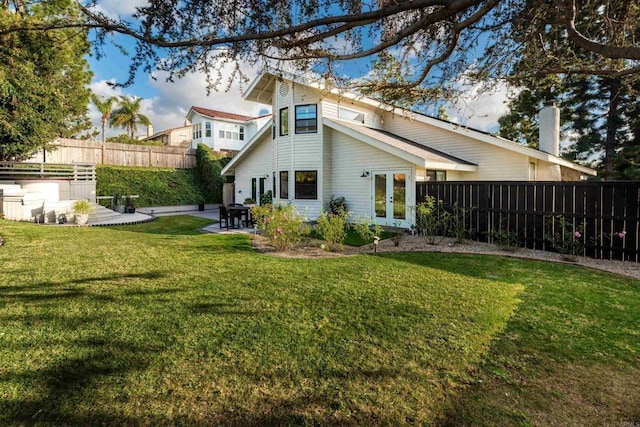 back of house with a patio, a yard, and french doors