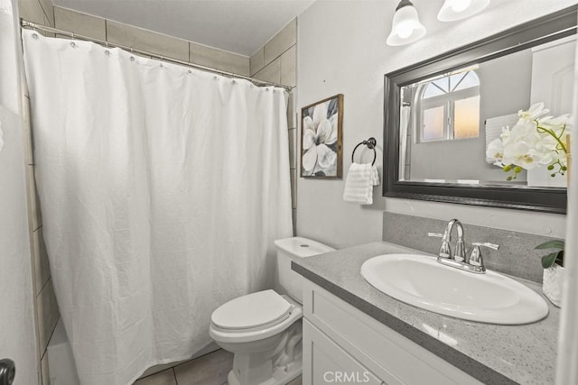 bathroom with vanity, toilet, curtained shower, and tile patterned flooring