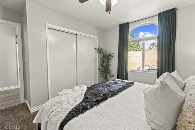 carpeted bedroom featuring ceiling fan and a closet