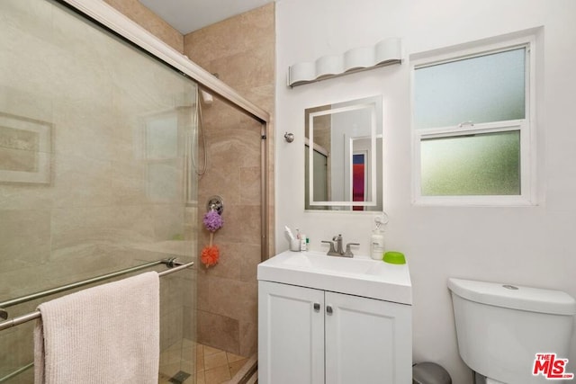 bathroom with walk in shower, vanity, and toilet