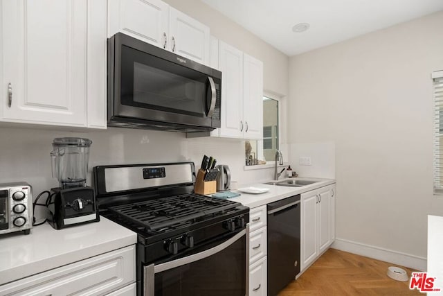 kitchen featuring sink, light parquet floors, dishwasher, white cabinetry, and stainless steel gas range oven