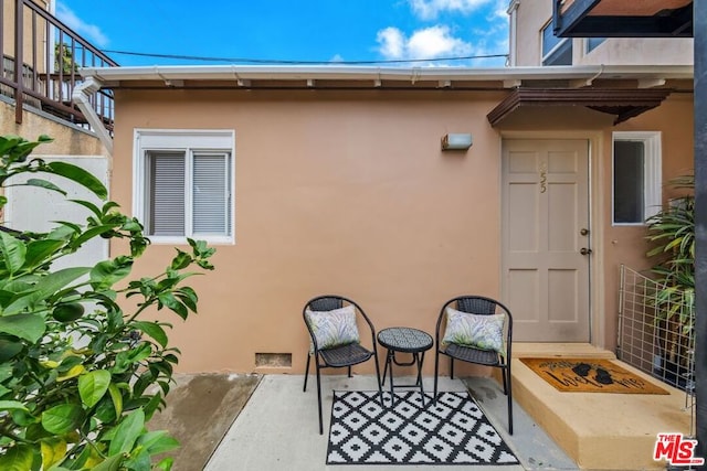 view of exterior entry with a patio area