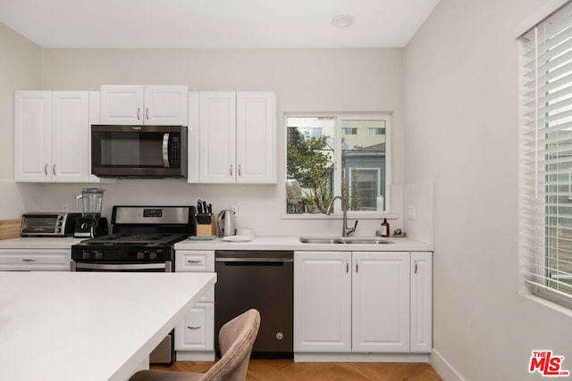 kitchen featuring white cabinetry, sink, and appliances with stainless steel finishes