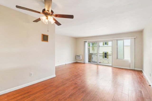 spare room featuring a wall mounted air conditioner, light hardwood / wood-style flooring, and ceiling fan