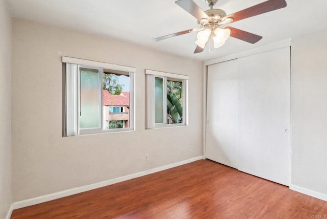 unfurnished bedroom featuring hardwood / wood-style flooring, a closet, and ceiling fan