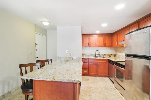 kitchen featuring a breakfast bar, sink, kitchen peninsula, stainless steel appliances, and light stone countertops