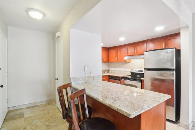 kitchen with a breakfast bar area, light stone countertops, kitchen peninsula, and appliances with stainless steel finishes