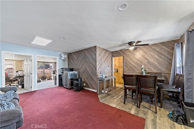 interior space with wood-type flooring, wooden walls, and ceiling fan