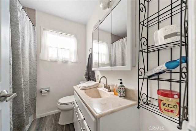 bathroom with hardwood / wood-style flooring, vanity, and toilet