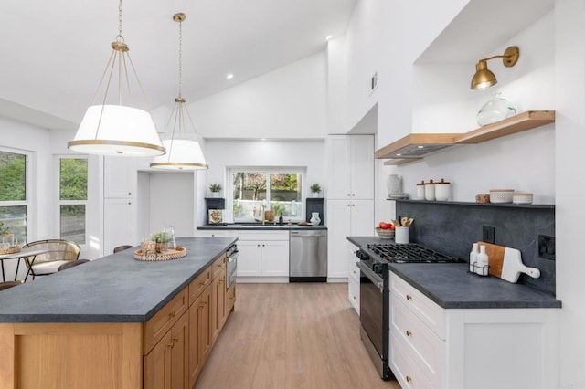 kitchen with white cabinetry, hanging light fixtures, dishwasher, a kitchen island, and gas range oven