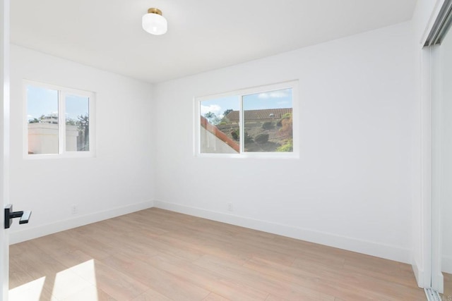 spare room with plenty of natural light and light hardwood / wood-style floors