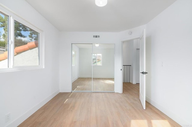 unfurnished bedroom with a closet and light hardwood / wood-style flooring