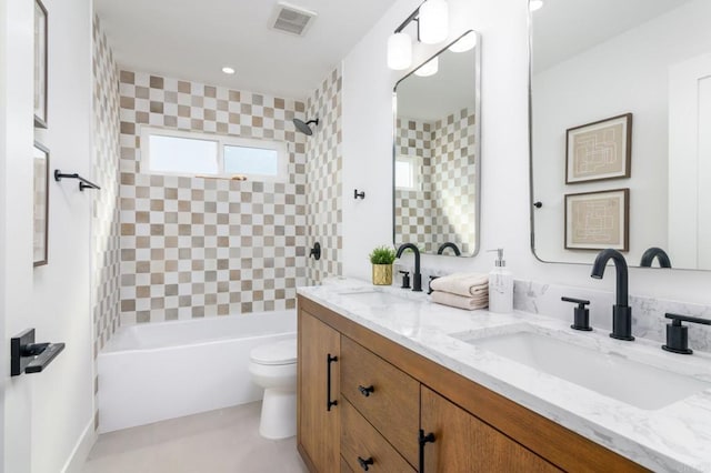 full bathroom featuring tiled shower / bath combo, vanity, and toilet