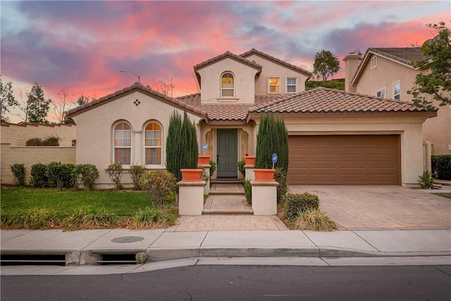 mediterranean / spanish-style house featuring a garage and a lawn