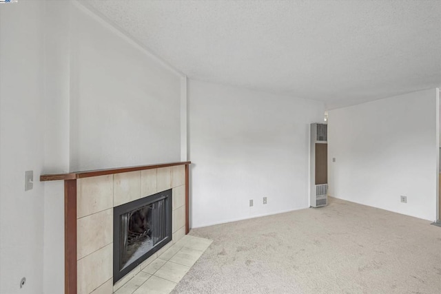 unfurnished living room featuring light colored carpet, a textured ceiling, and a fireplace