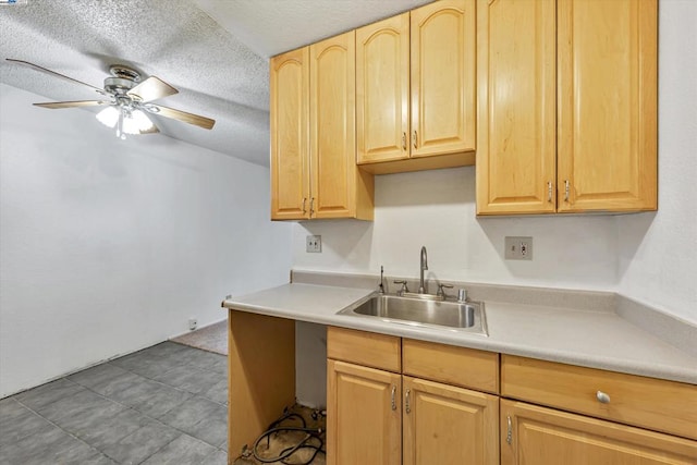 kitchen with sink, a textured ceiling, light brown cabinetry, and ceiling fan