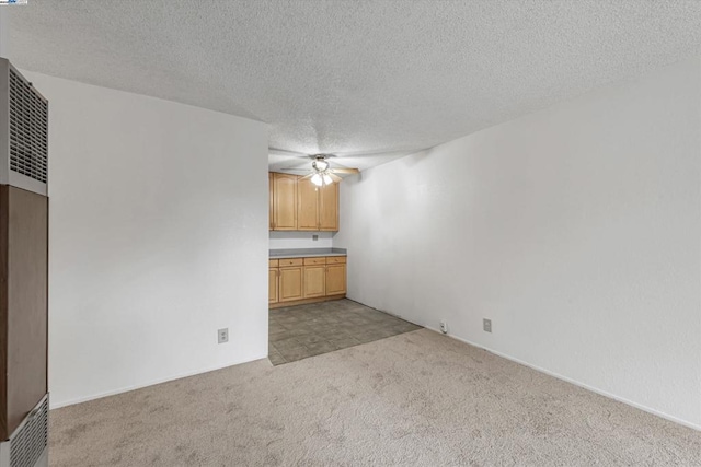 unfurnished living room with light colored carpet, a textured ceiling, and ceiling fan