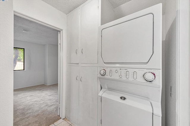 washroom featuring stacked washer and clothes dryer, light carpet, and a textured ceiling