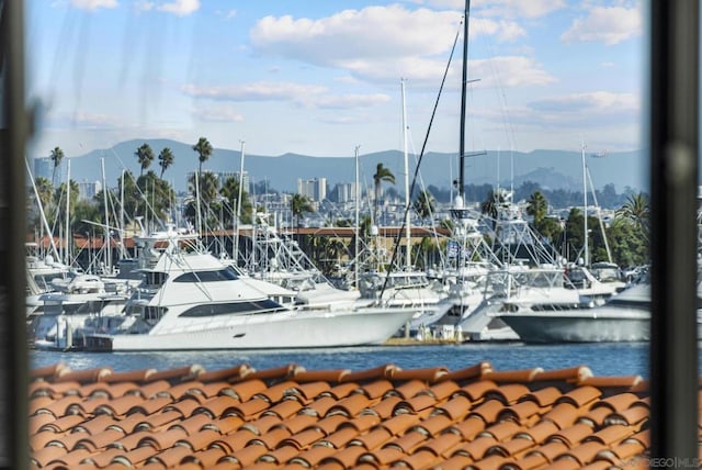 surrounding community featuring a water and mountain view and a boat dock