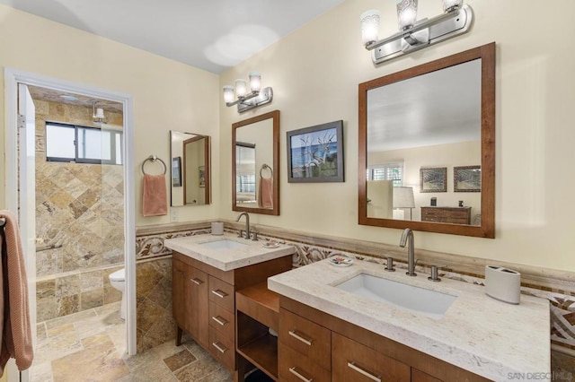 bathroom with vanity, toilet, and tile walls