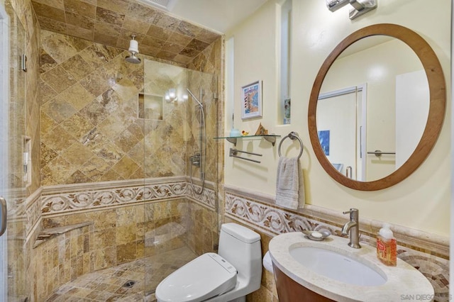 bathroom with tiled shower, vanity, and toilet