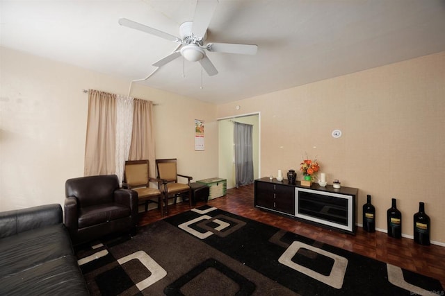 living room featuring ceiling fan and dark parquet flooring