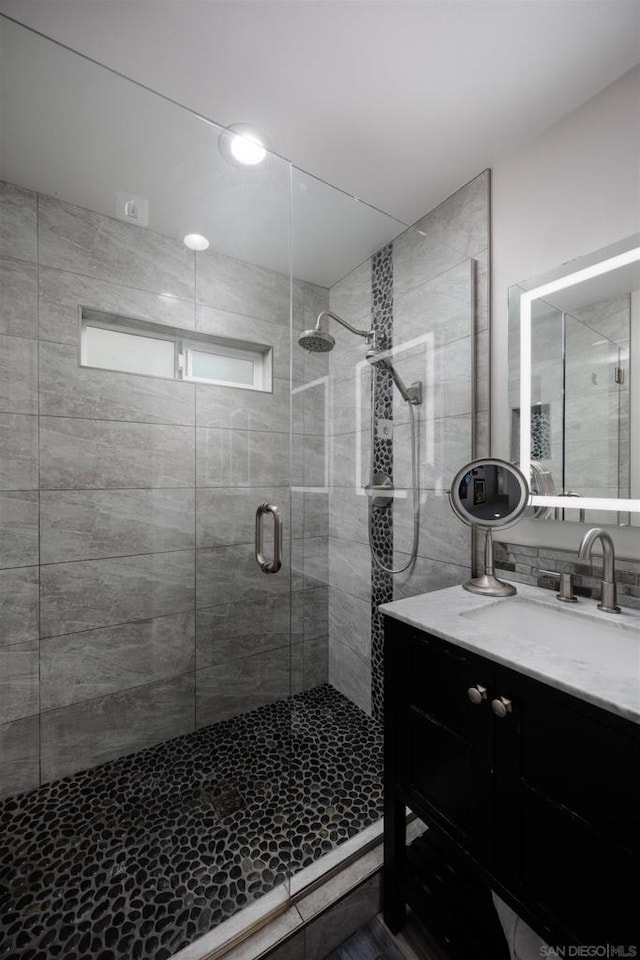 bathroom featuring vanity and a shower with shower door