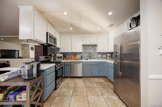 kitchen featuring sink, white cabinetry, light tile patterned floors, stainless steel appliances, and backsplash