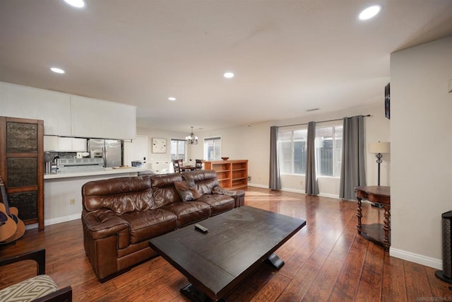 living room with dark hardwood / wood-style floors and a chandelier