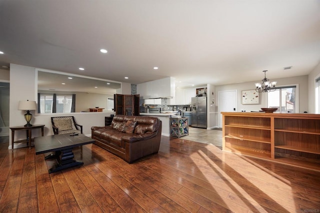 living room with hardwood / wood-style flooring and an inviting chandelier