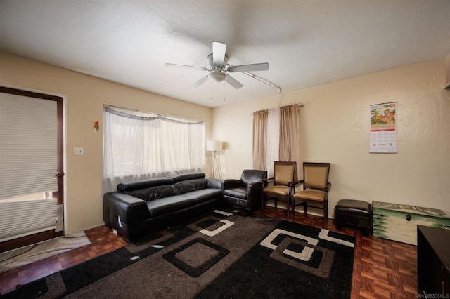 living room featuring ceiling fan and dark parquet floors