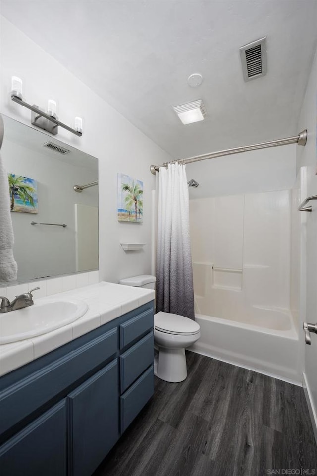 full bathroom featuring hardwood / wood-style flooring, vanity, shower / bathtub combination with curtain, and toilet