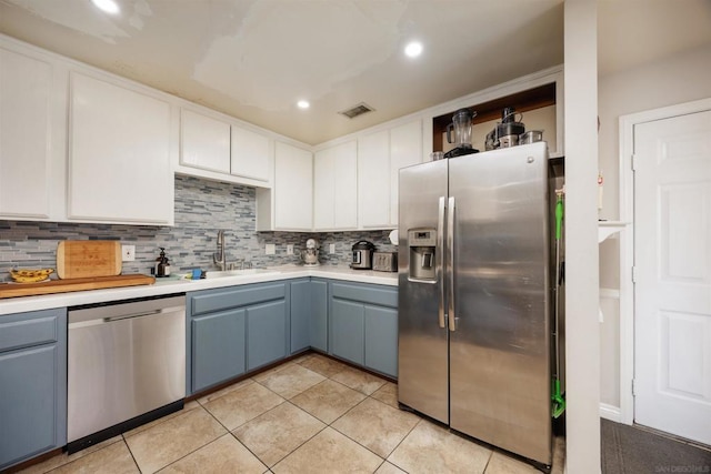 kitchen featuring sink, decorative backsplash, white cabinets, and appliances with stainless steel finishes