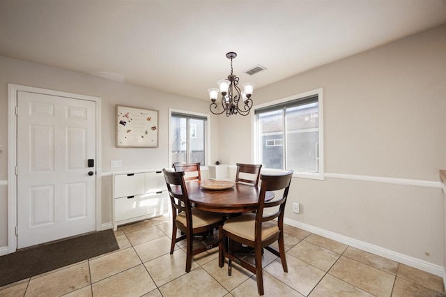 tiled dining room with a chandelier