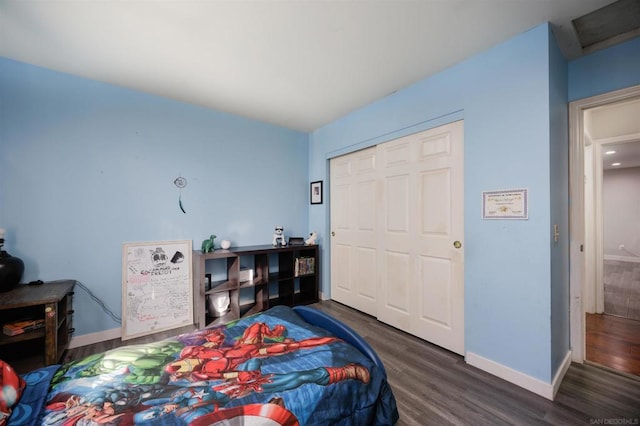 bedroom with dark wood-type flooring and a closet